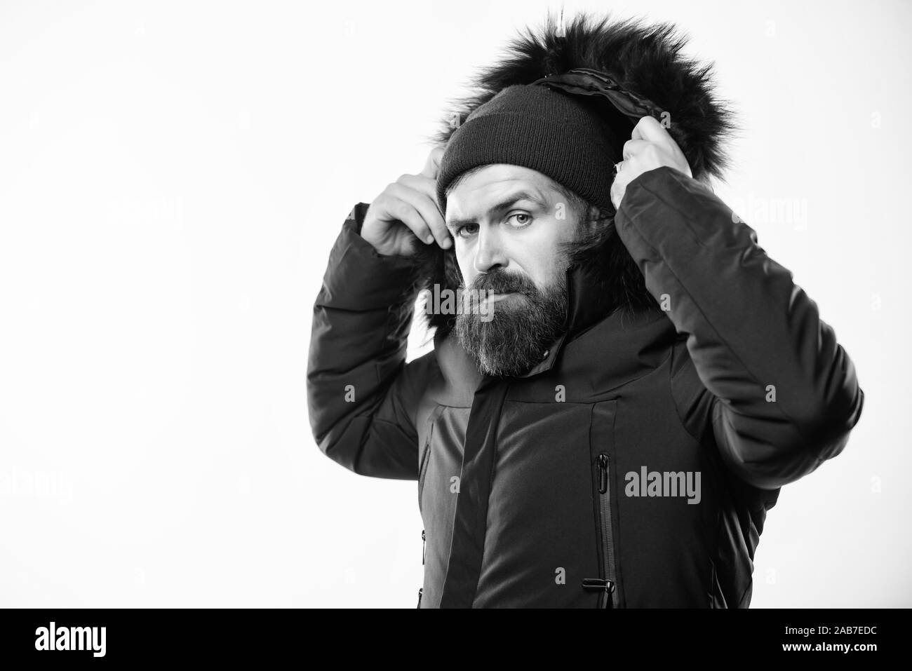 Il cofano si aggiunge il calore e la resistenza alle intemperie. Come scegliere la miglior giacca invernale. Uomo Barbuto stand giacca calda parka isolati su sfondo bianco. Stagione invernale menswear. Resistente agli agenti atmosferici jacket. Foto Stock