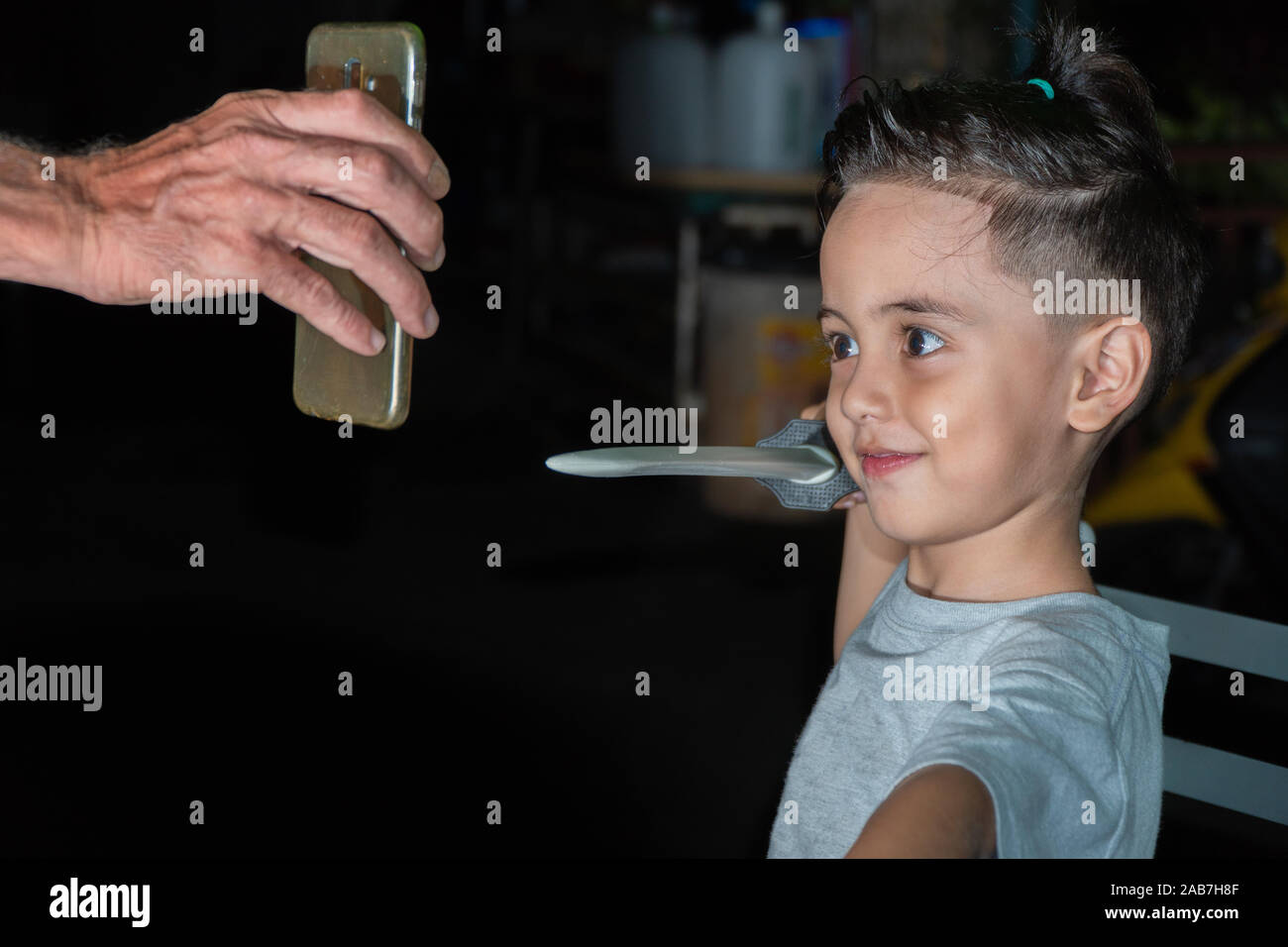 Il ragazzo ha una pettinatura pungenti, fingendo di essere la scherma per mostrare sul mobile. Foto Stock