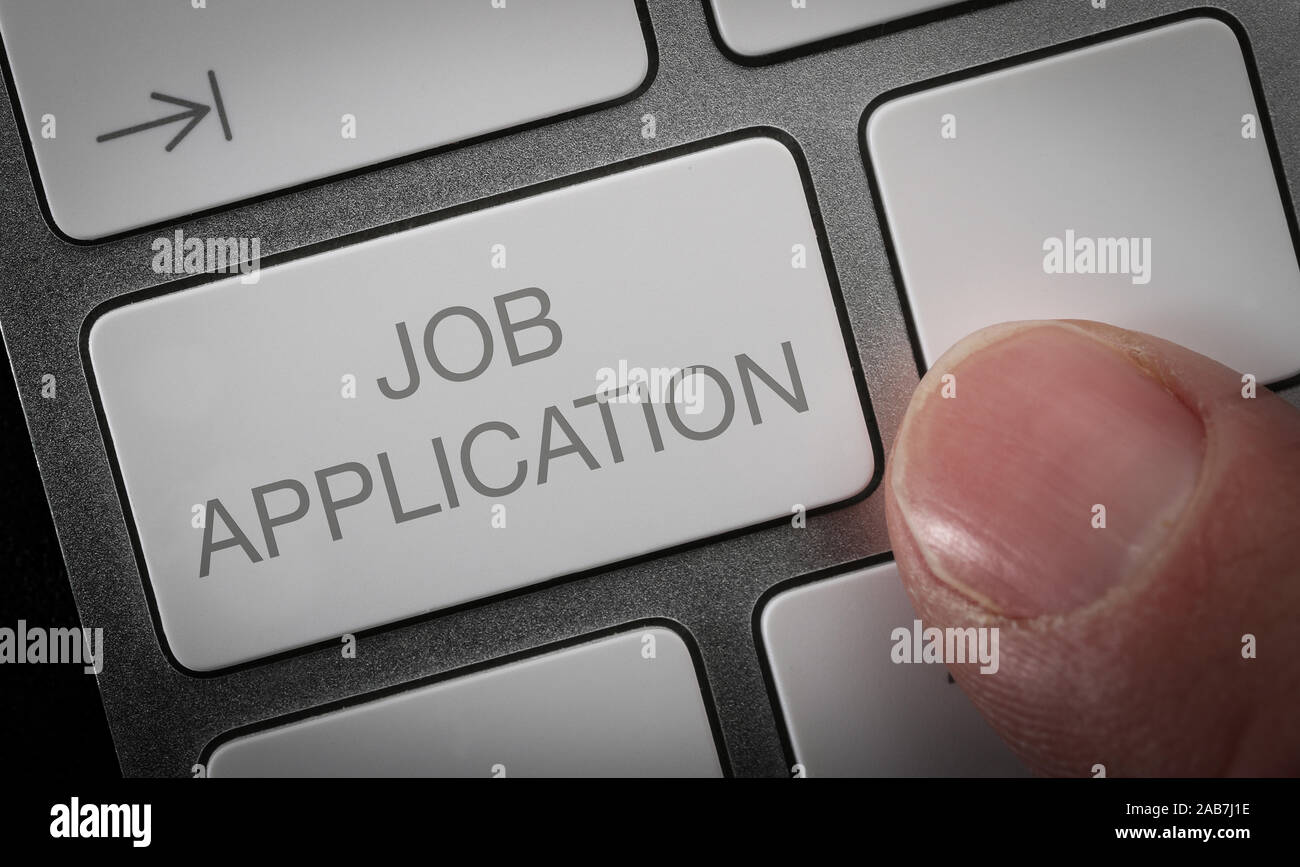 Un uomo premendo un tasto sulla tastiera di un computer con le parole domanda di lavoro. In linea di ricerca di lavoro Concetto di immagine. Foto Stock