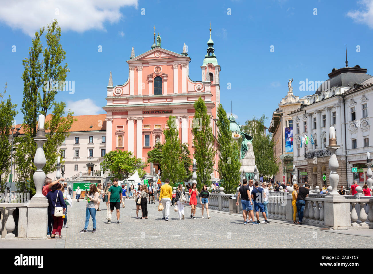 La Rosa chiesa francescana in Piazza Preseren e turisti camminando sul ponte triplo, centrale Ljubljana, Slovenia, Europa Foto Stock