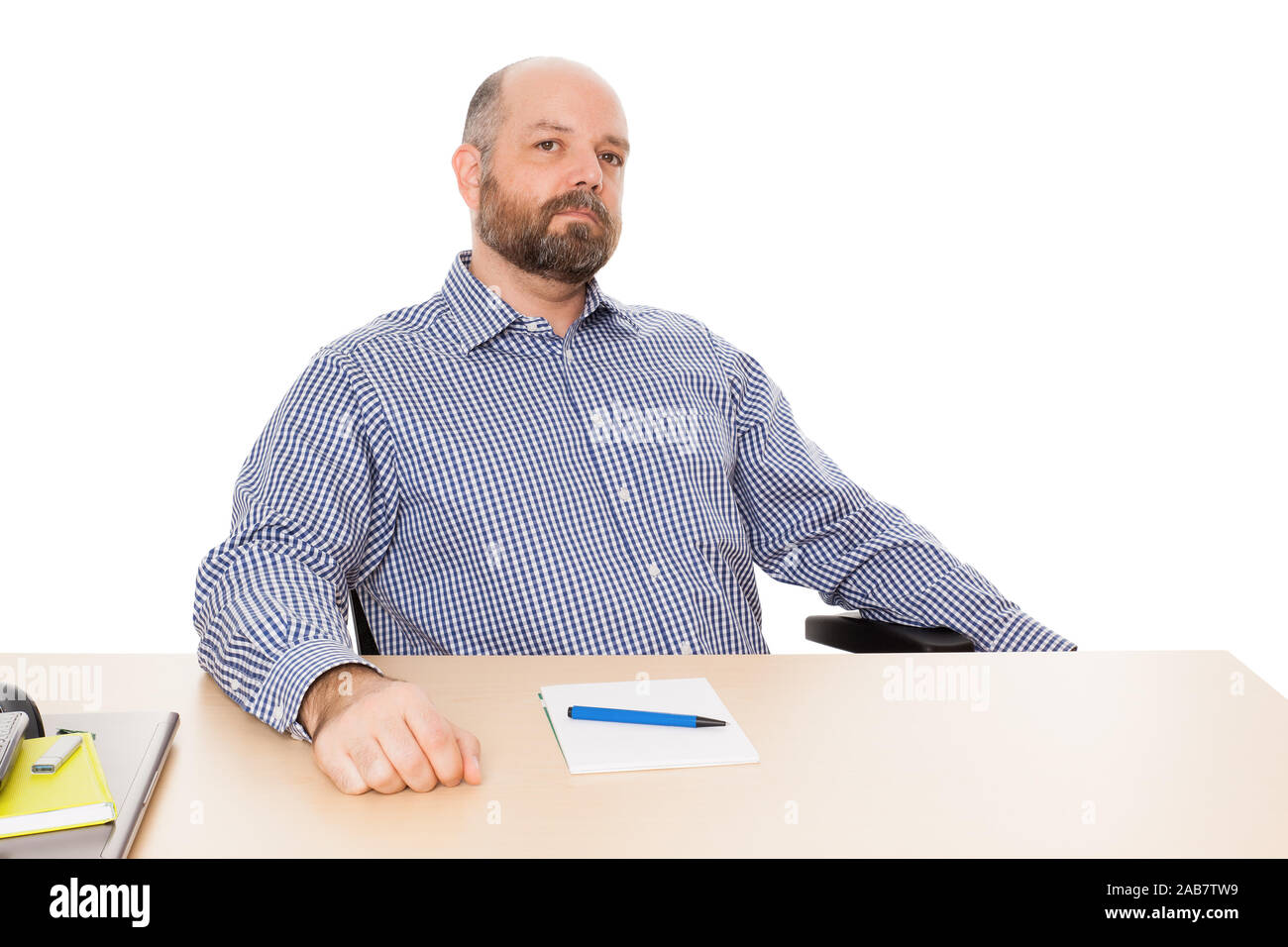 Ein Mann mit Bart un seinem Schreibtisch vor weissem Grund Foto Stock