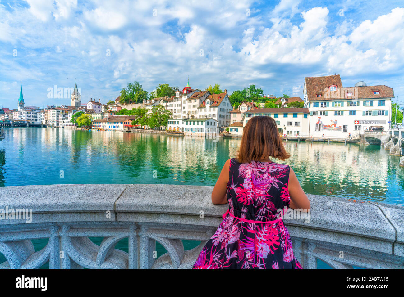 Vista posteriore della donna appoggiata sulla terrazza sul fiume Limmat ammirando i vecchi edifici del Lindenhof, Zurigo, Svizzera, Europa Foto Stock
