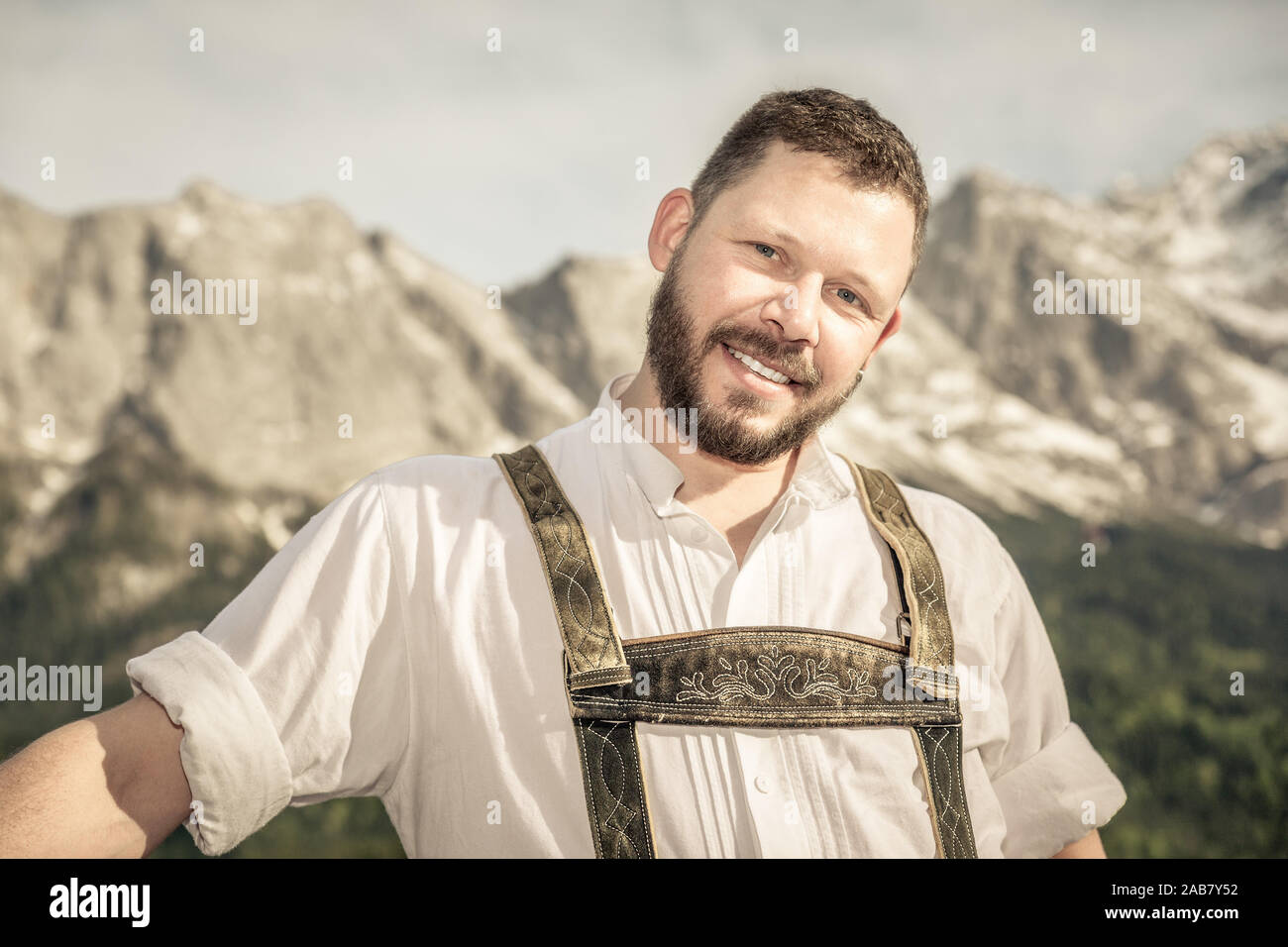 Ein junger Mann in Tracht vor einer Bergkulisse Foto Stock