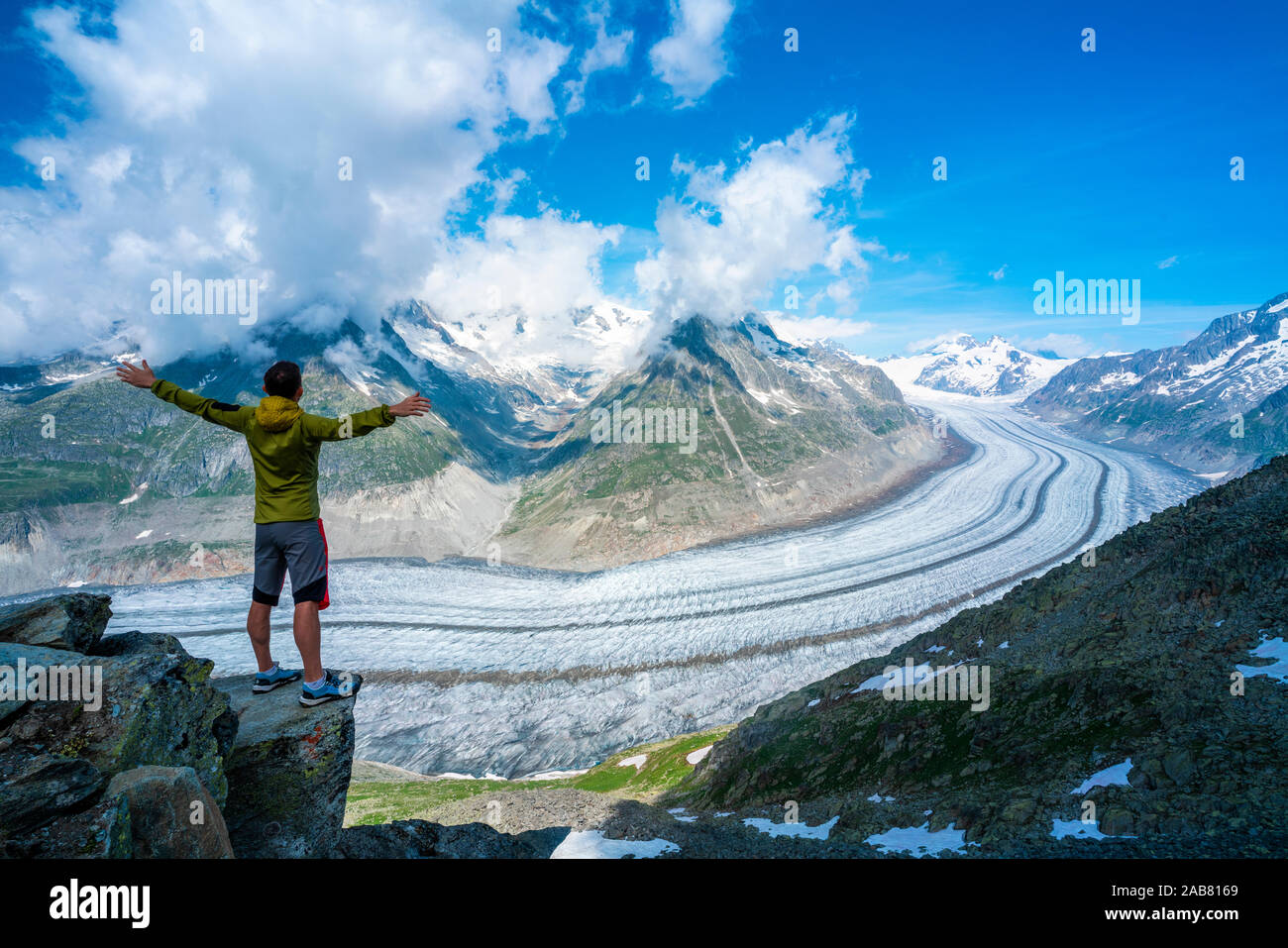 L'uomo esultando con le braccia tese guardando il ghiacciaio di Aletsch dal punto di vista Eggishorn, Alpi Bernesi, canton Vallese, Svizzera, Europa Foto Stock