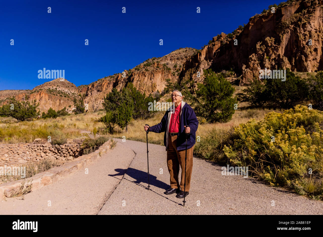 Il vecchio uomo che cammina attraverso il Pueblo Indian rovine di Bandelier National Monument, Nuovo Messico, America del Nord Foto Stock