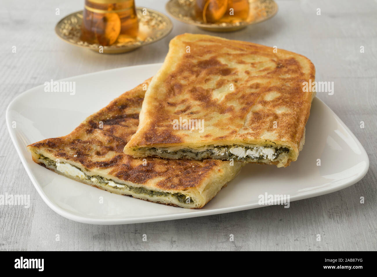 Tradizionale turca frittelle farcite con spinaci e formaggio feta isolato su un piatto di portata Foto Stock