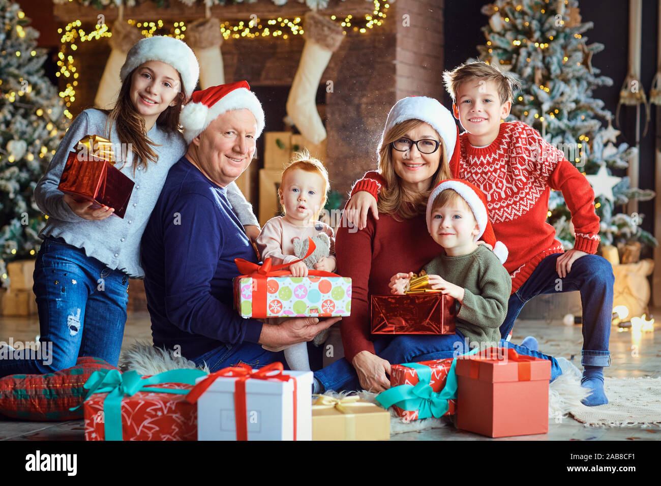Nonna e nonno con i bambini a casa durante il periodo di Natale. Foto Stock