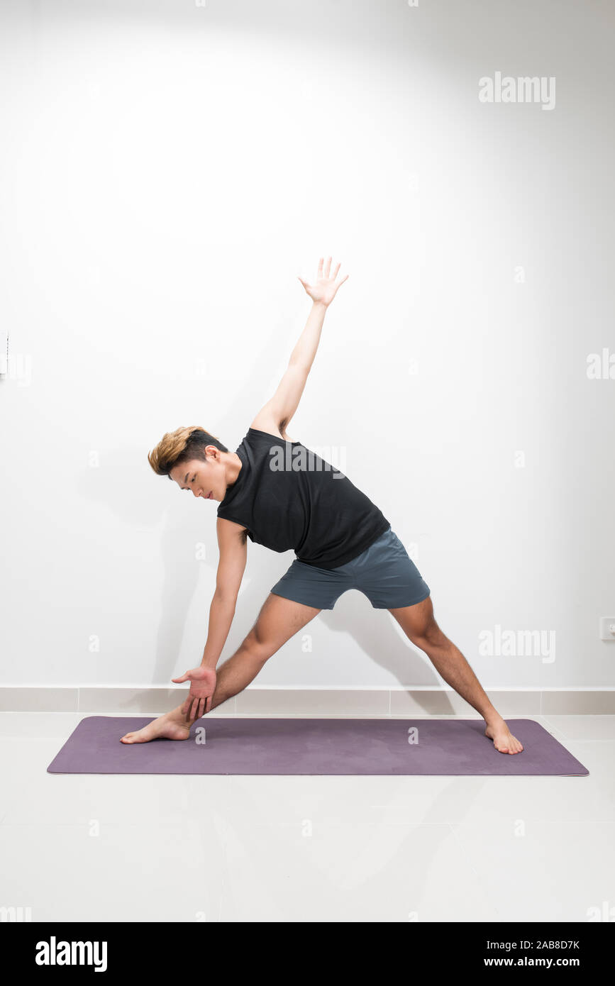 Un uomo che fa esercizi yoga. Studio shot su sfondo bianco. Foto Stock