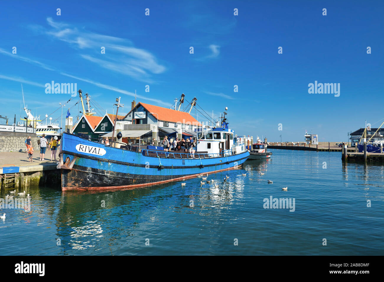Barca blu chiamato 'rivale' ancorata al porto di Oudeschild con persone a bordo che offre pesca sportiva escursioni per i turisti su isola di Texel Foto Stock