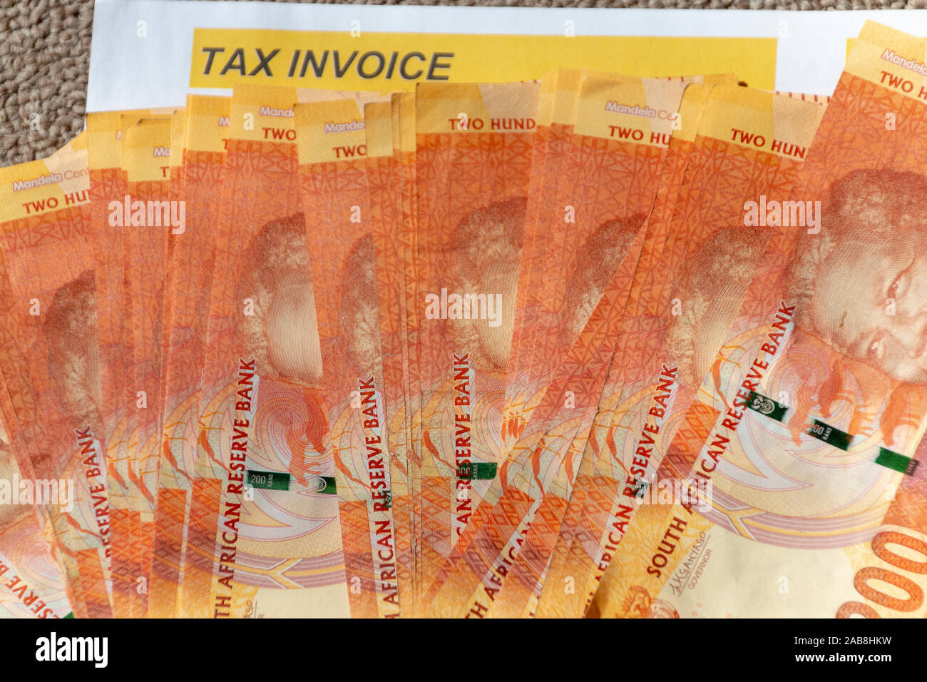 Una vista ravvicinata di una pila di due hundered rand note sulla sommità di una fattura fiscale bill Foto Stock