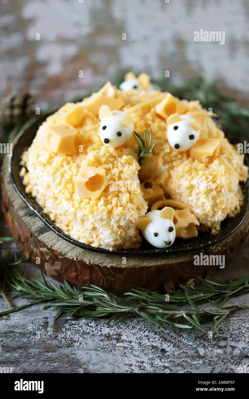 Anno Nuovo 2020 insalata. Mouse in insalata di formaggio con ananas e formaggio. Le decorazioni a forma di uovo topi. Foto Stock