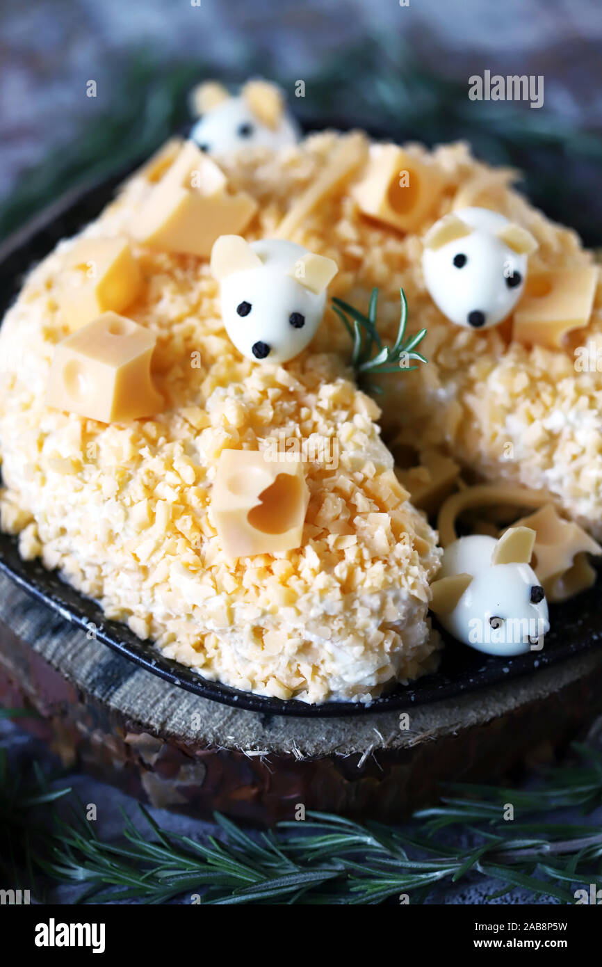Anno Nuovo 2020 insalata. Mouse in insalata di formaggio con ananas e formaggio. Le decorazioni a forma di uovo topi. Foto Stock