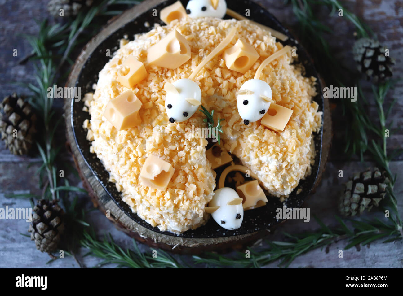 Anno Nuovo 2020 insalata. Mouse in insalata di formaggio con ananas e formaggio. Le decorazioni a forma di uovo topi. Foto Stock