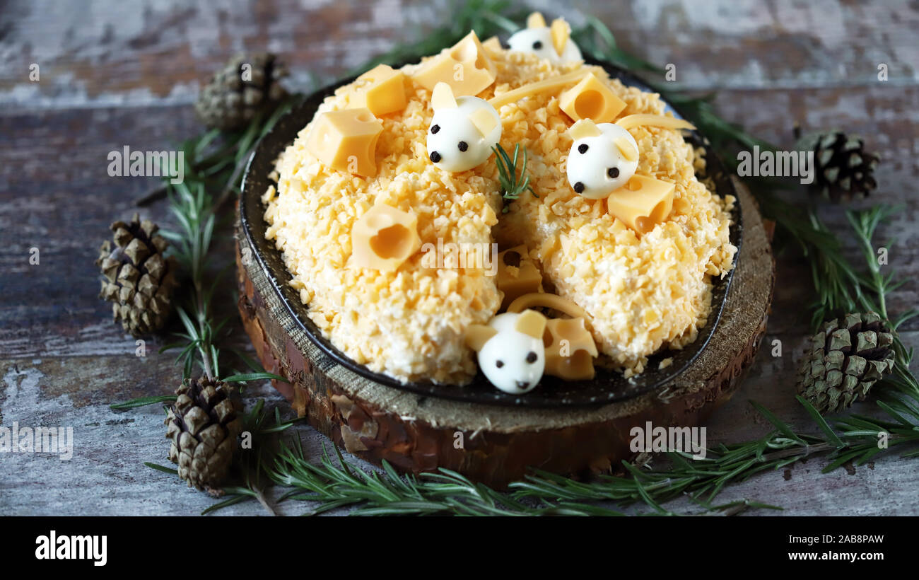 Anno Nuovo 2020 insalata. Mouse in insalata di formaggio con ananas e formaggio. Le decorazioni a forma di uovo topi. Foto Stock