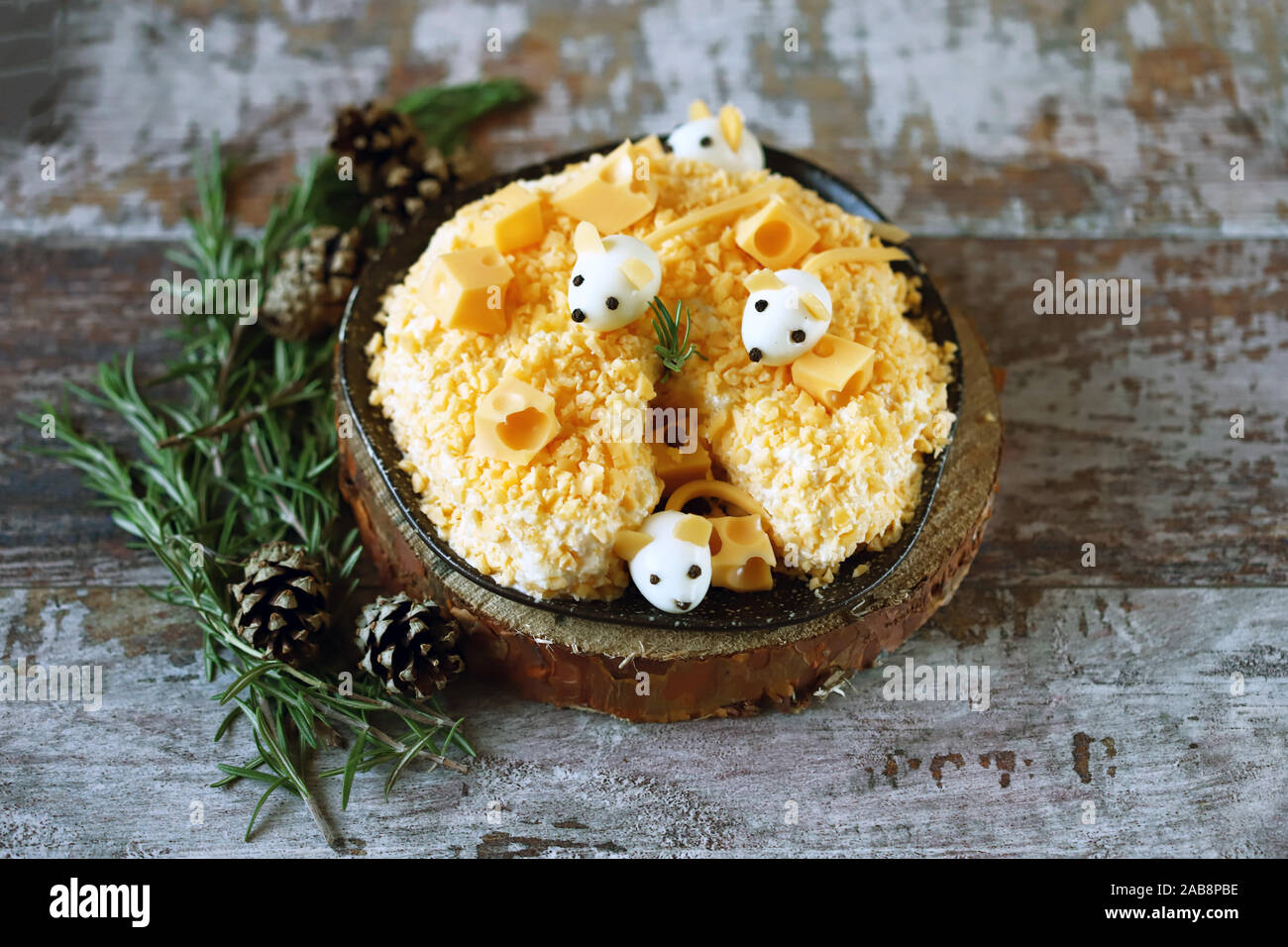 Anno Nuovo 2020 insalata. Mouse in insalata di formaggio con ananas e formaggio. Le decorazioni a forma di uovo topi. Foto Stock