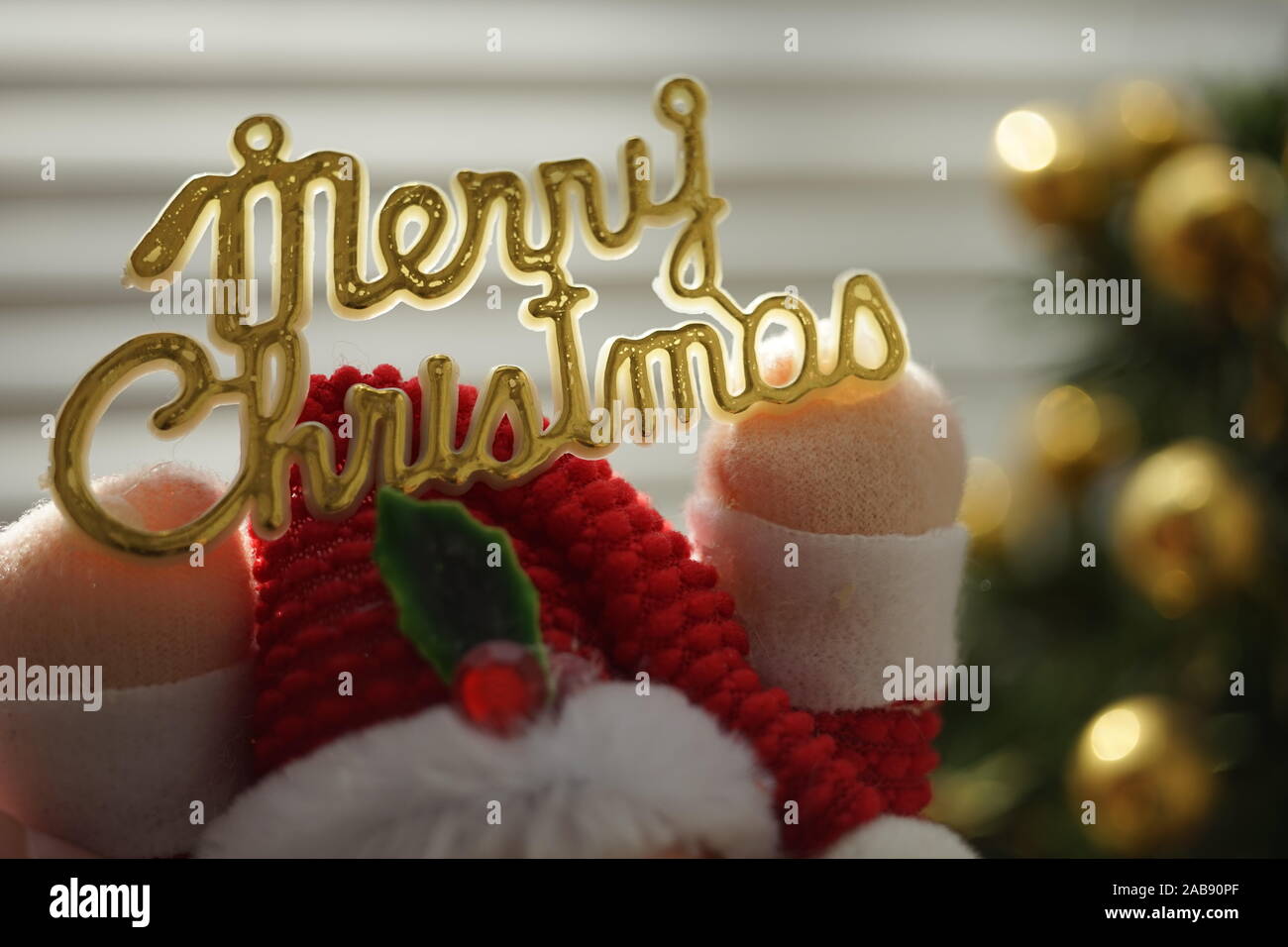 Golden testo Mery Christmas in giocattolo Santa Claus mani. Foto Stock