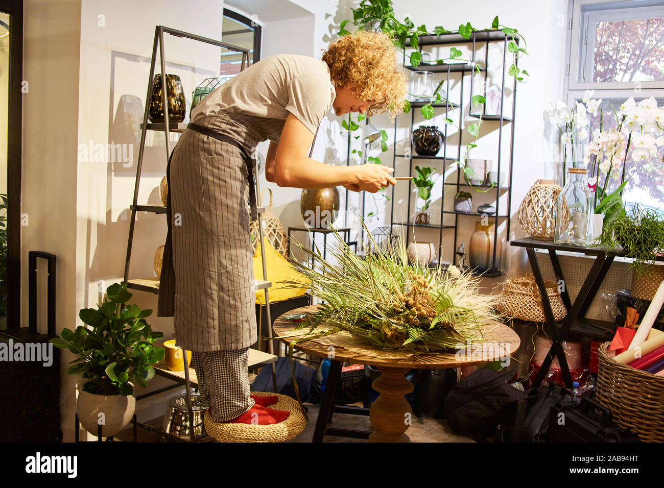 Fioraio creativo nel suo negozio di fiori di legatura del mazzo Foto Stock