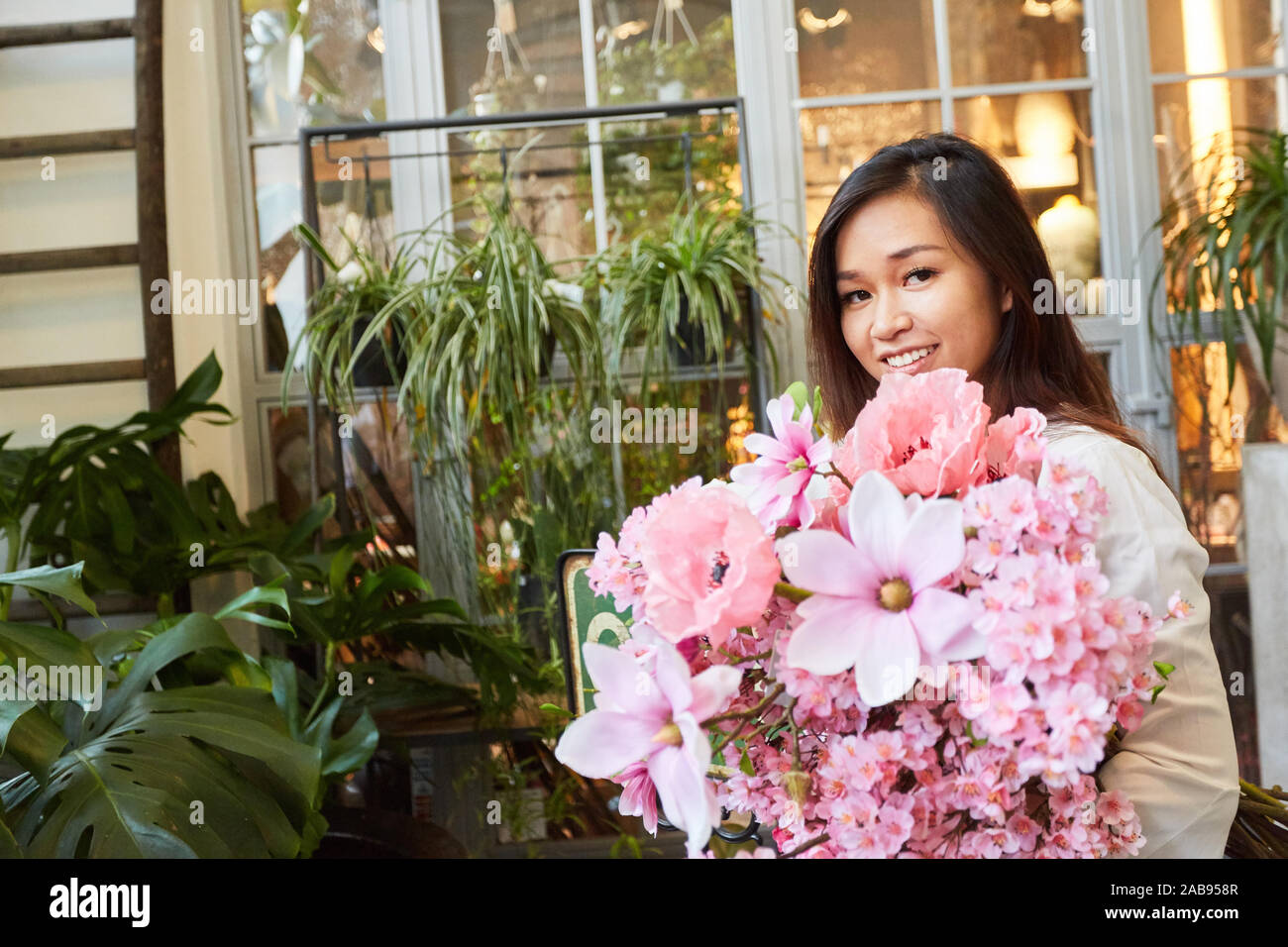 Fioraio nella consegna di grandi bouquet di colore rosa per la Festa della mamma Foto Stock