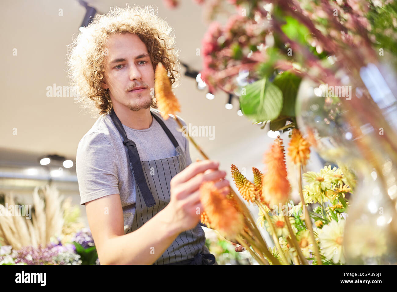 Fiorista o partecipante controlla i fiori recisi nel suo negozio di fiori Foto Stock