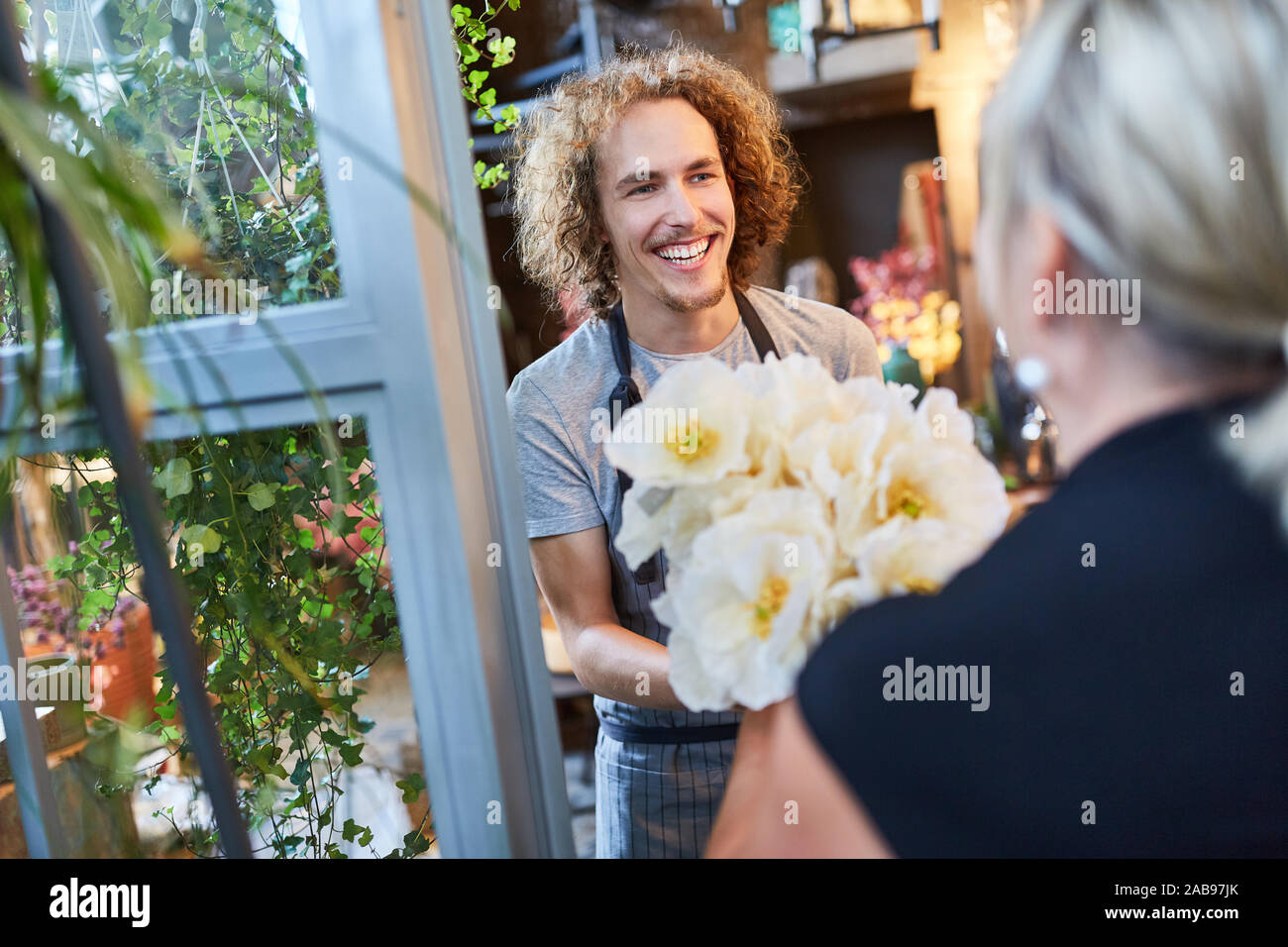 Fioraio alla consegna di un mazzo di fiori ordinato home Foto Stock