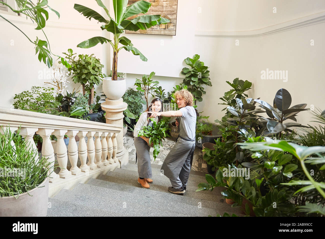 Due i fioristi di fiorai evento presso il catering per nozze con molte piante verdi Foto Stock