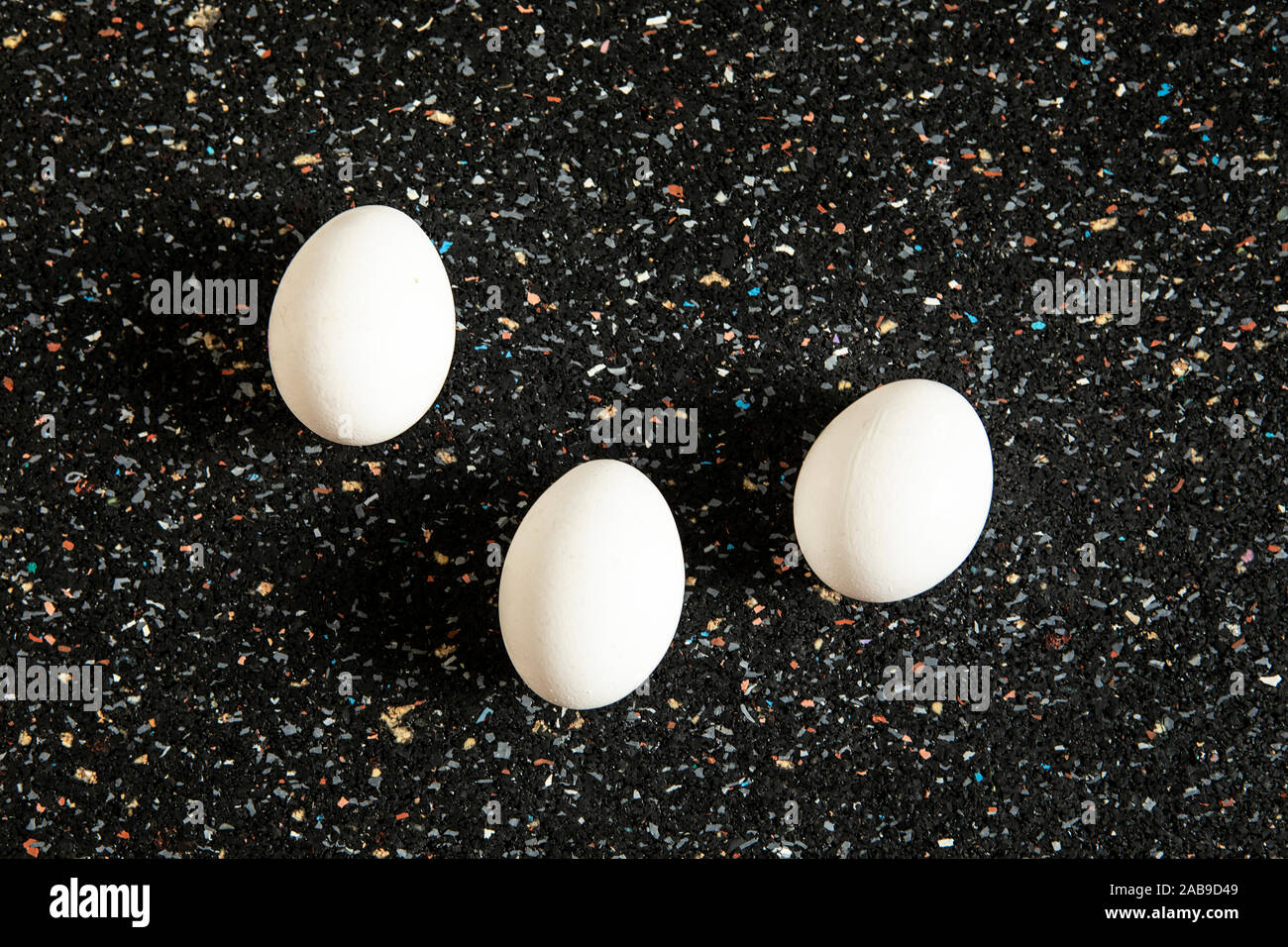 Still Life, disposizione astratta con uova di albero giace sul nero sfondo maculato. Nuovo concetto di vita. Bianco minimalista ovoidale laici piana, cibo arte. Pop Foto Stock