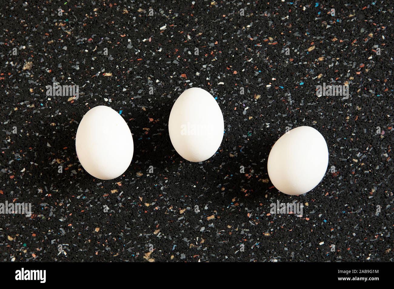 Still Life, disposizione astratta con uova di albero giace sul nero sfondo maculato. Nuovo concetto di vita. Bianco minimalista ovoidale laici piana, cibo arte. Pop Foto Stock
