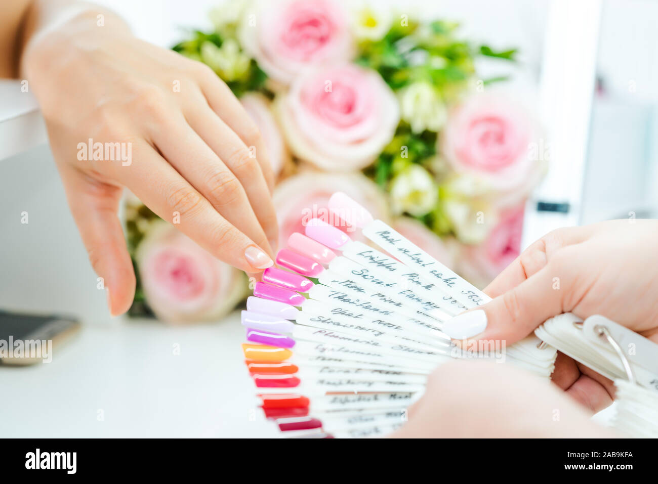 La donna durante il manicure scegliendo un colore per unghie Foto Stock