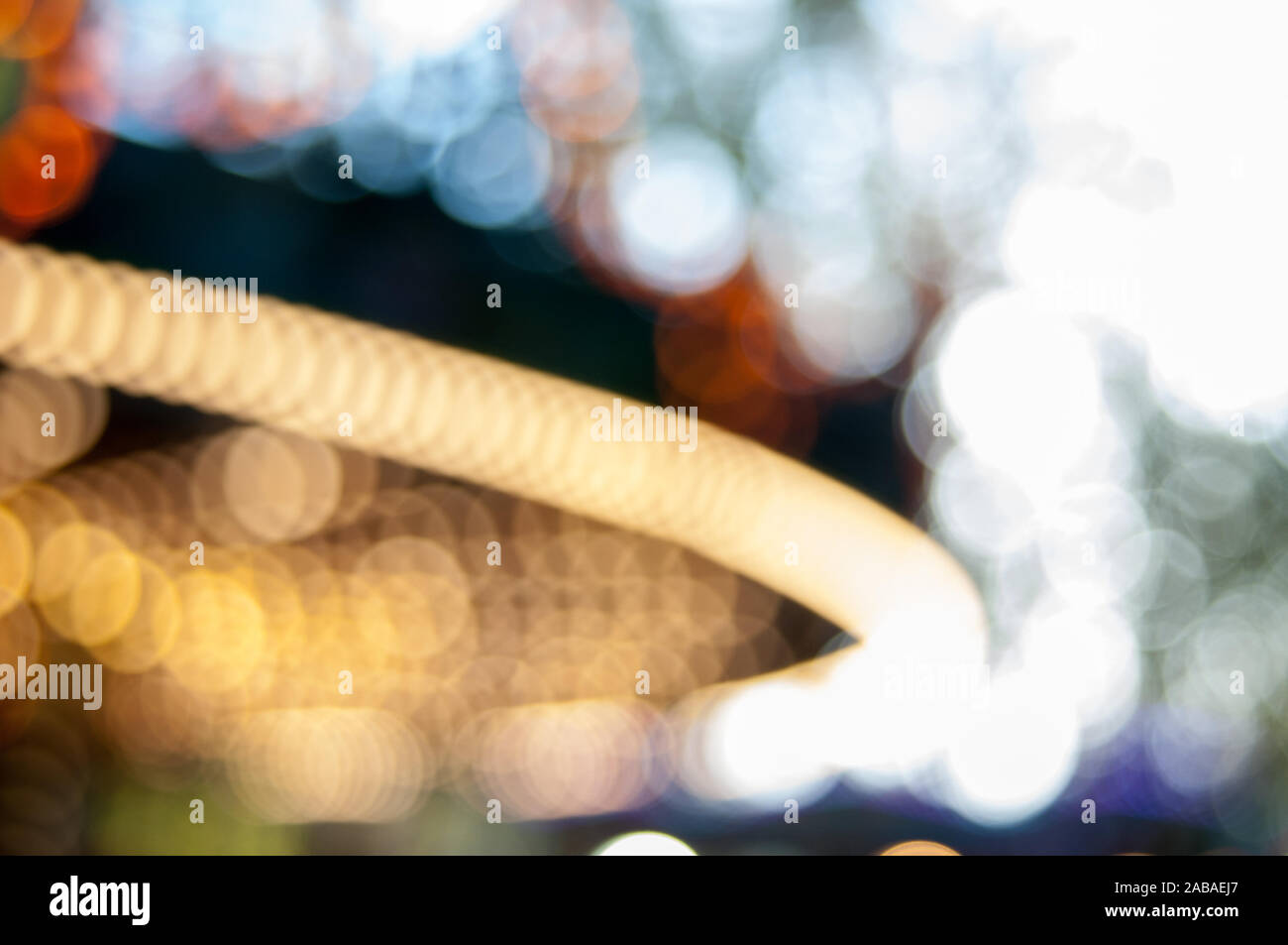 Vista di sfocatura di una giostra in una fiera del divertimento di notte - sfondo bokeh di fondo Foto Stock