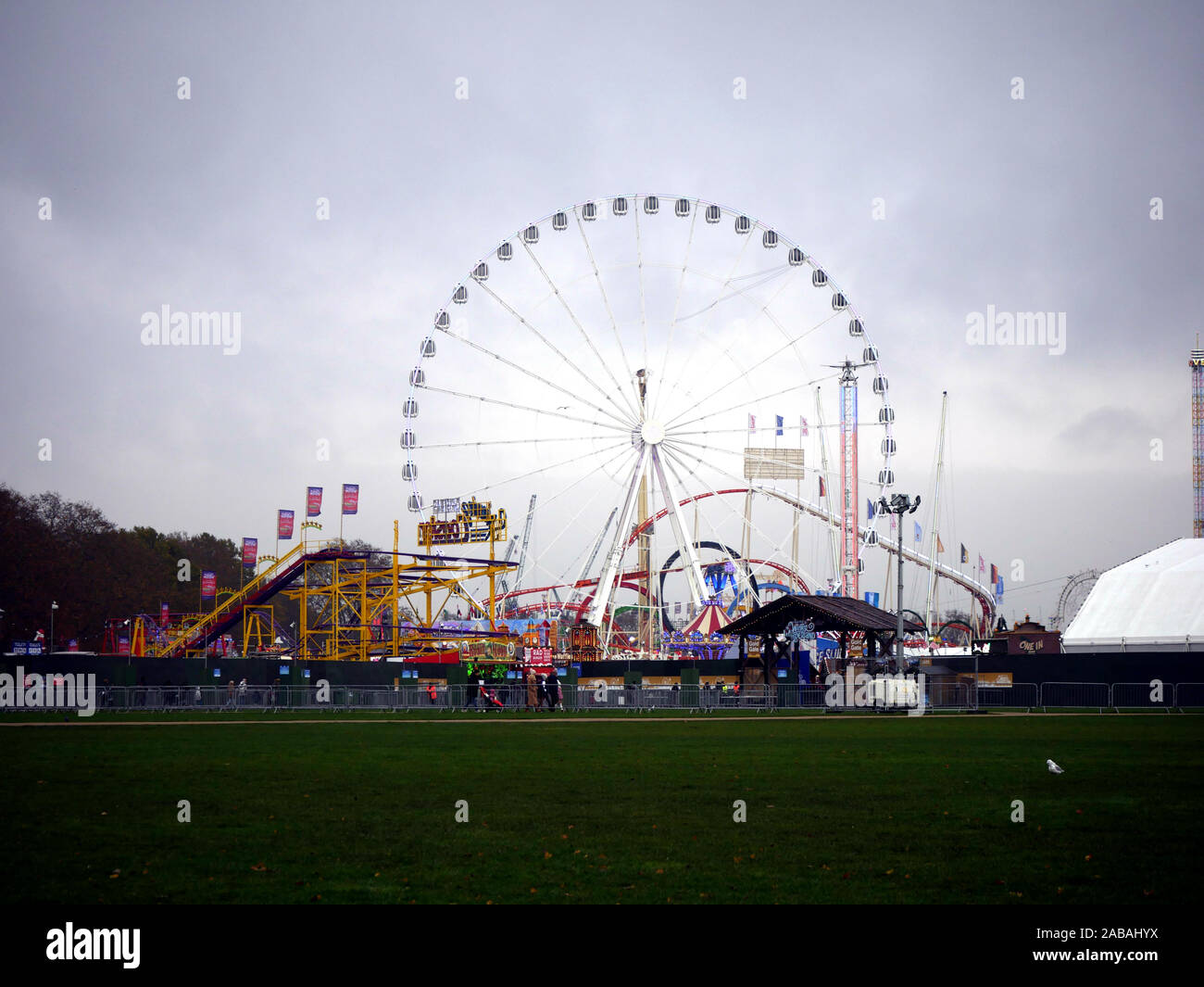 Vista l'enorme ruota e le montagne russe al Winter Wonderland, Hyde Park, London, Regno Unito. Ruota è il più grande trasportabile in Europa. Foto Stock