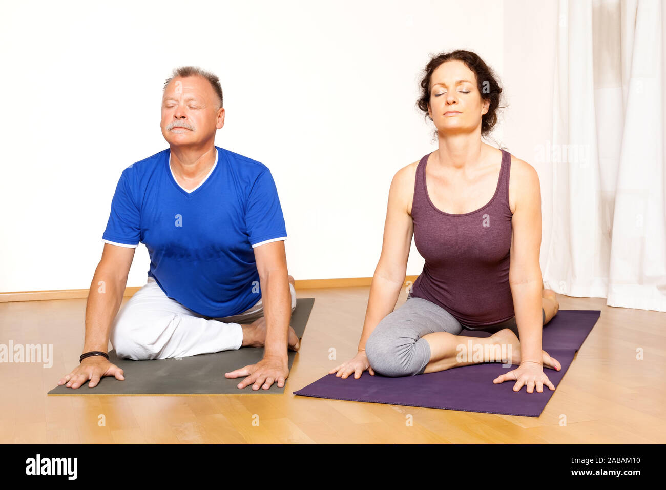 Maenner und Frauen, die Yoga-Uebungen durchfuehren Foto Stock