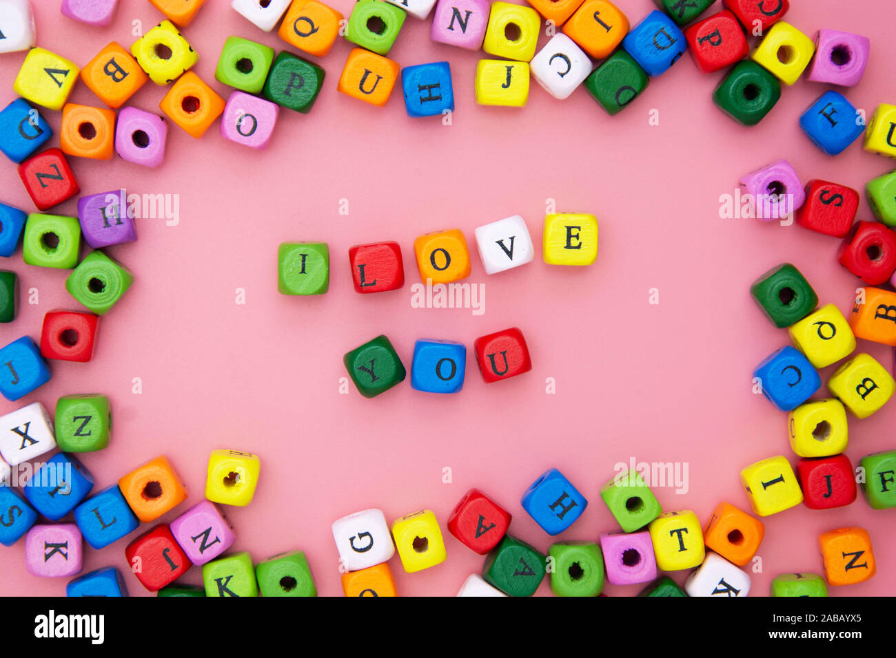 Ti amo parola, scritte su sfondo rosa. Il giorno di San Valentino, amicizia, Giornata della madre. Blocchi colorati parola d'amore. Foto Stock