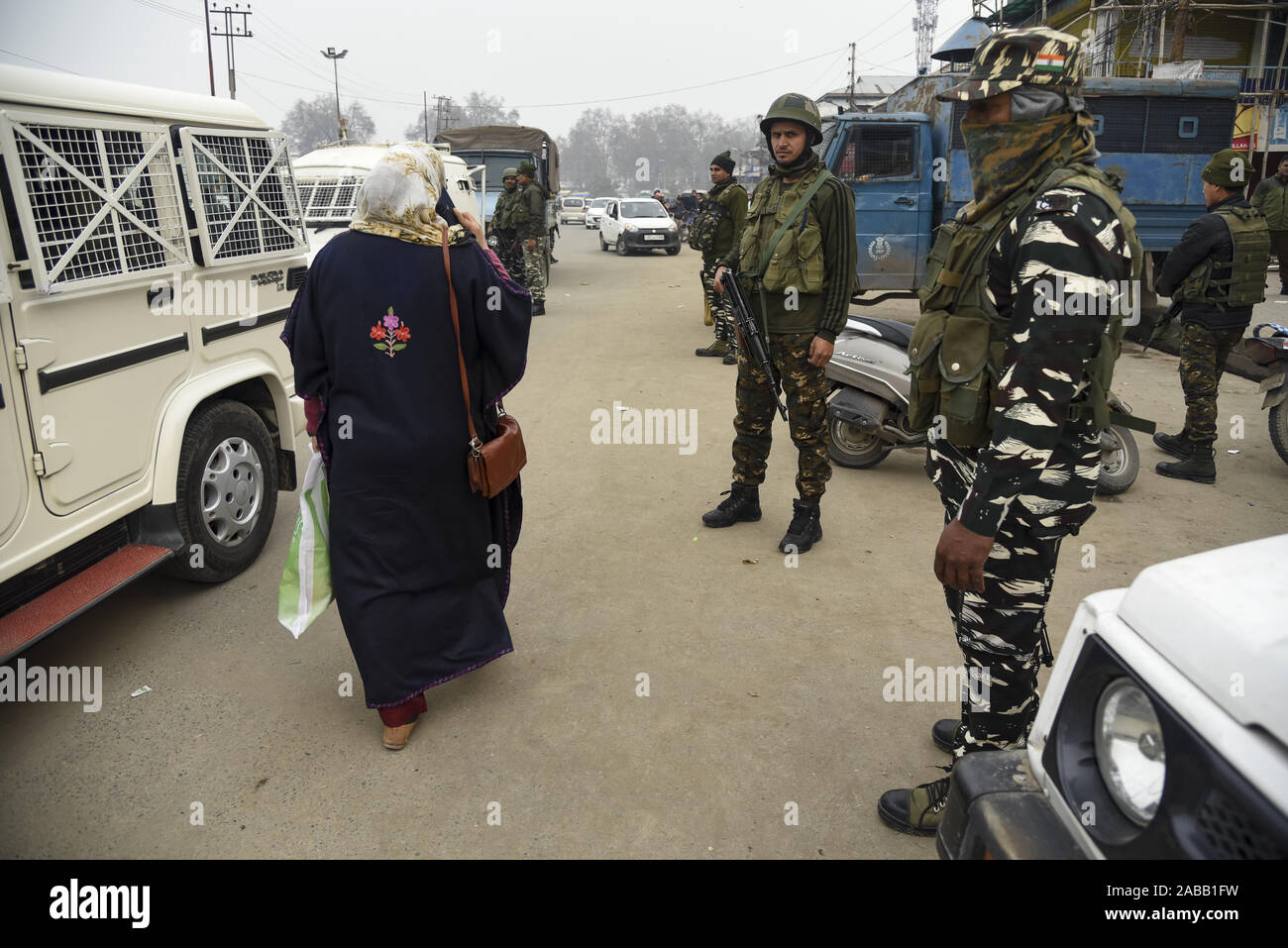 Una donna del Kashmir passeggiate passato indiano forze paramilitari di guardia vicino al sito di blast.almeno tre persone sono state ferite in una bassa intensità per esplosione che ha avuto luogo a Hazratbal località in Srinagar city, la capitale estiva di Indiano-Kashmir amministrato, la polizia ha detto. Foto Stock