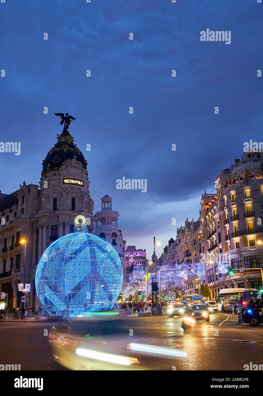 Gran Via al calar della sera illuminata da luci di Natale e un lucido palla di Natale. Vista dalla strada di Alcala. Foto Stock