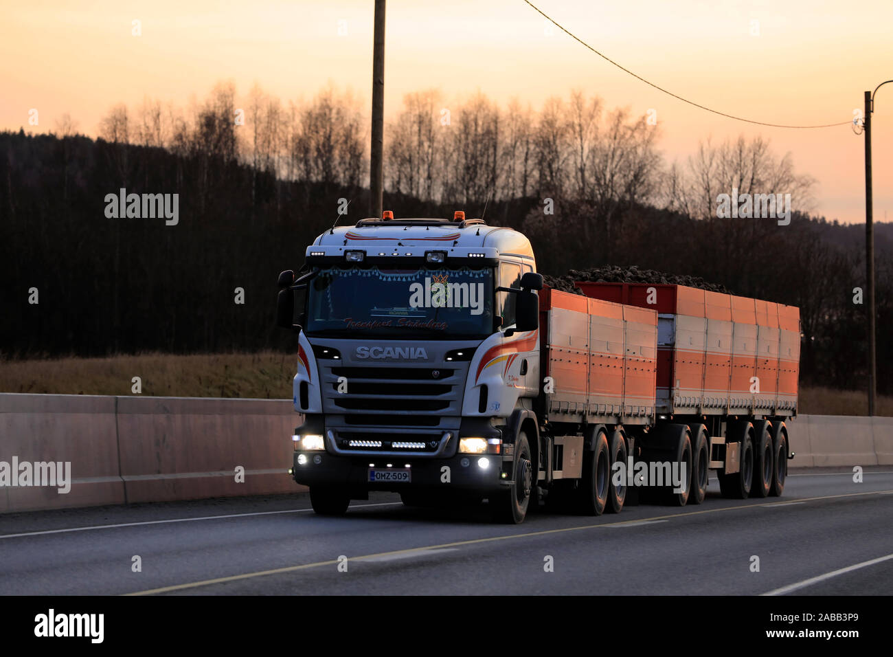 Scania carrello di trasporto Stromberg offre la barbabietola da zucchero di fabbrica di zucchero in Sakyla, Finlandia lungo l'autostrada 52 al tramonto. Salo, Finlandia. Nov 23, 2019. Foto Stock