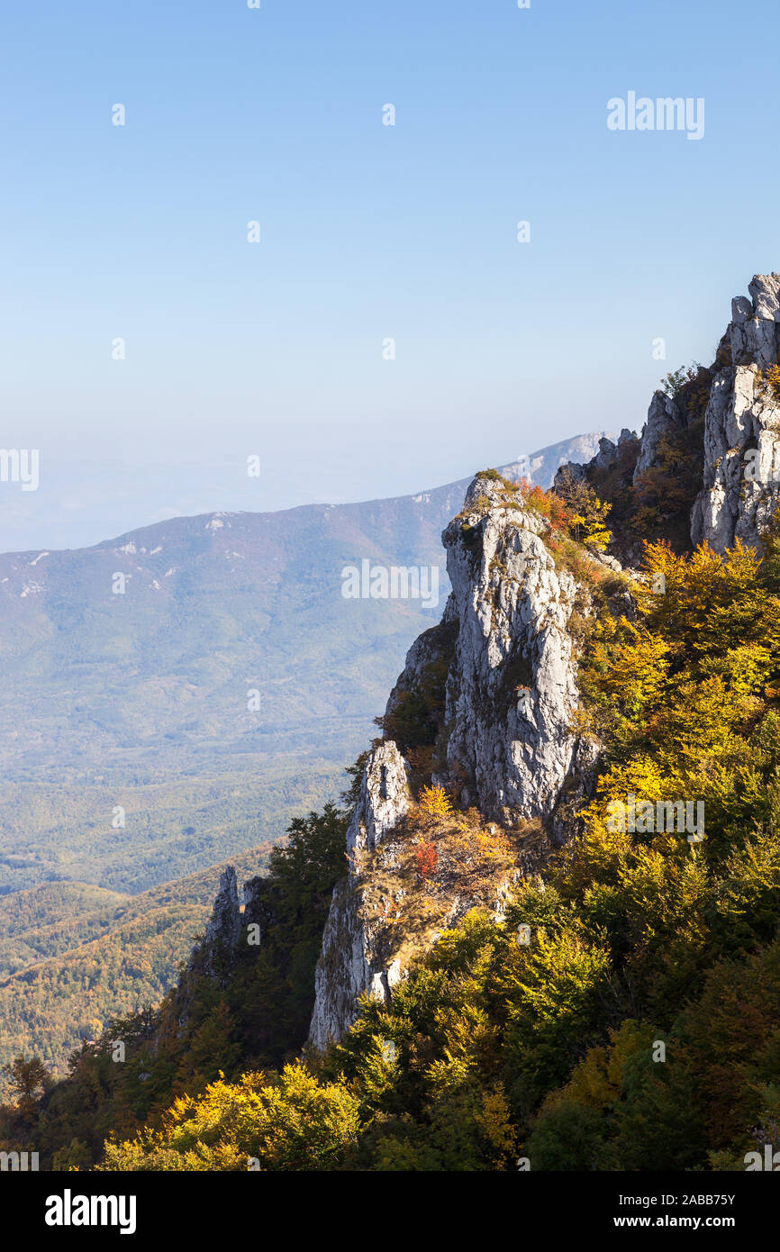 Incredibile roccioso, appuntito di cliff coperti da bushed nel colore di autunno e golden, soleggiato, foreste di montagna Foto Stock