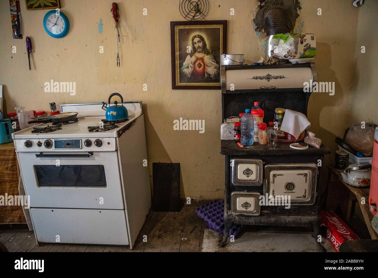 Cucina, stufa a legna, orologio da parete, piatti, pentole, casella di religiosi, Gesù Cristo, e gli interni della casa del cowboy Ruben Arviuzu Reyes, nella città di Pilares de Nacozari. Ruben si prende cura delle vecchie costruzioni della città fantasma che è anche una città turistica o abbandonato la città mineraria. Pilares, è una città nel comune di Nacozari de García, Sonora, Messico, nella zona superiore della Sierra Madre Occidental. Dal 1960 è noto come una città fantasma a causa della sua spopolamento nel 1920s, a causa della chiusura e di eliminazione delle società minerarie che sono state qui. © © (© Foto: LuisGutierrez NorteP Foto Stock