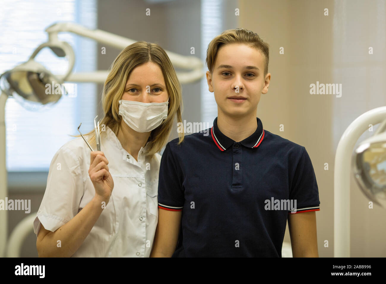 Ragazzo adolescente e paziente donna di dentista, insieme ritratto in camera dentale. Foto Stock