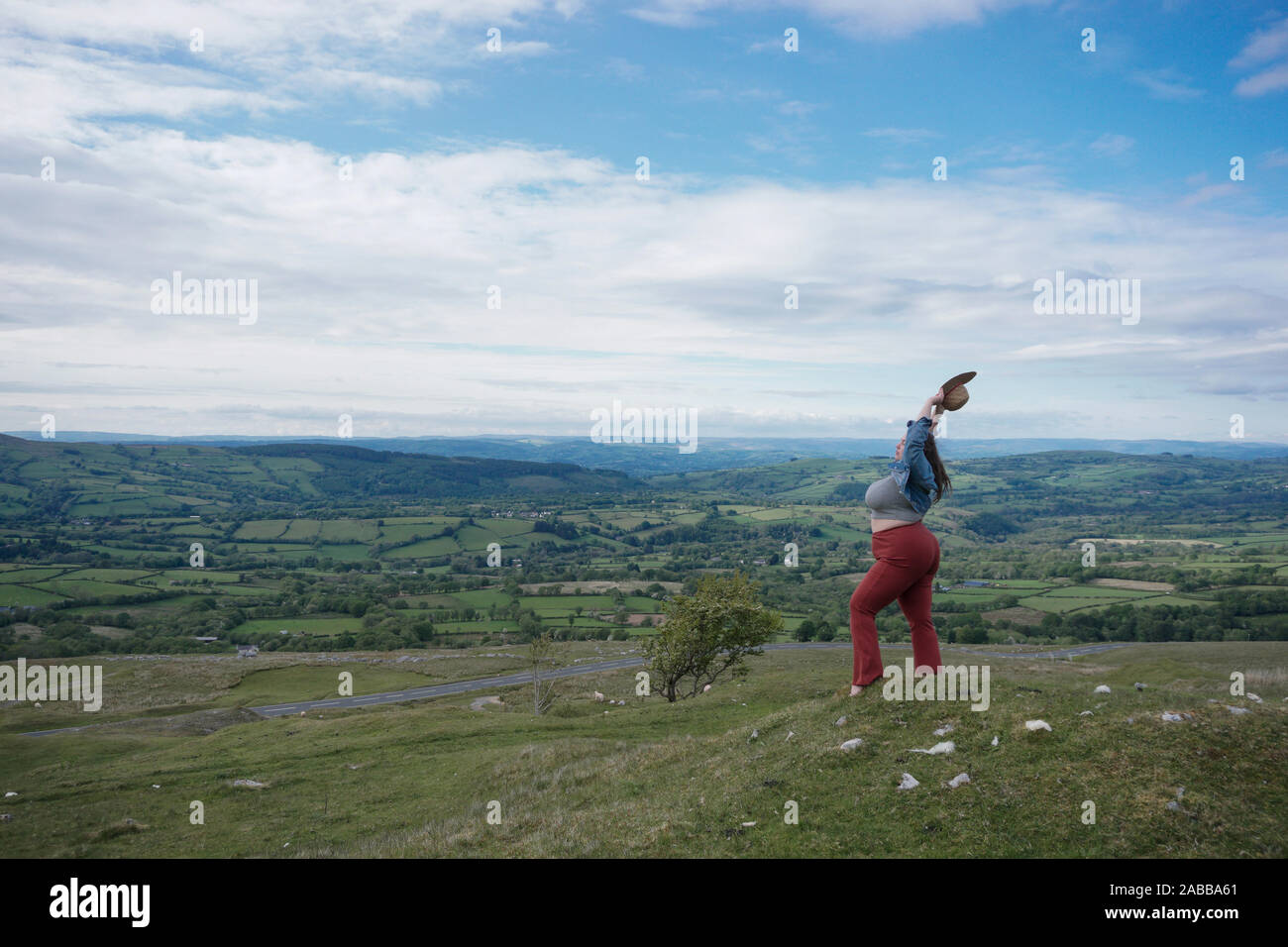Bella donna tenendo le braccia in aria, le montagne nere, Powys, Snowdonia, Wales, Regno Unito Foto Stock