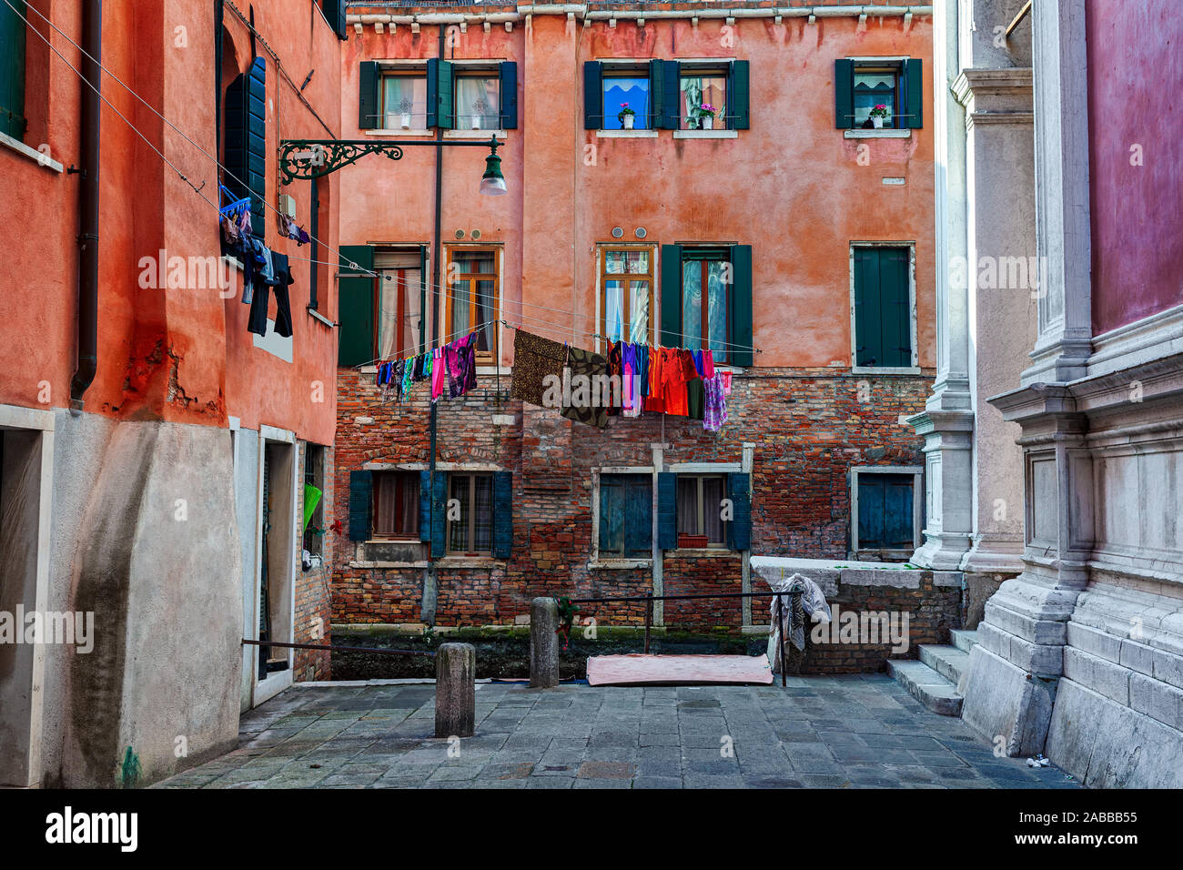 Piccolo quadrato circondato dalle tipiche case colorate con servizio lavanderia su windows a Venezia, Italia. Foto Stock