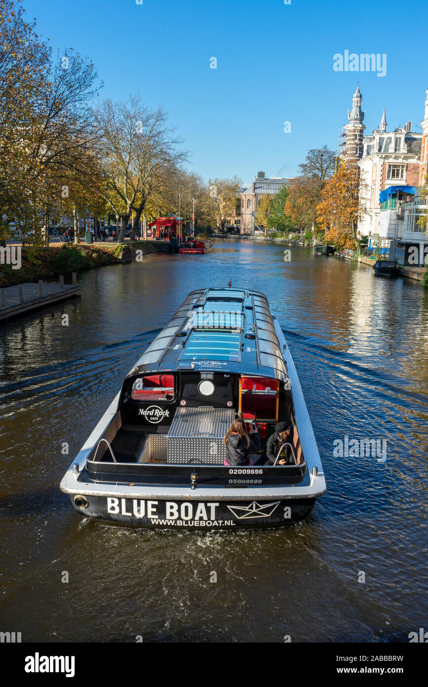 Barche in canali di Amsterdam, i colori autunnali e cielo blu Foto Stock