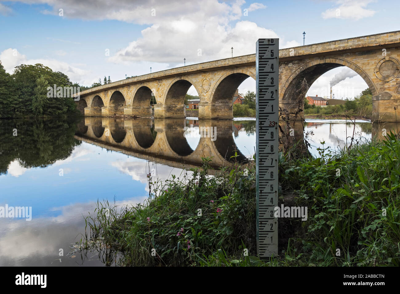 Acqua/livello di inondazione marcatore sul fiume Tyne a Hexham con Hexham road ponte che attraversa il fiume in Northumberland, Regno Unito. Foto Stock