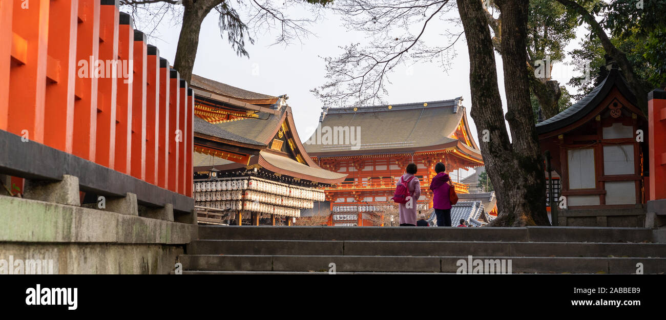 Due Signore in kimono a piedi tra Yasaka-Jinja Shrine Nishiromon Gate e Maidono, Kyoto, Giappone Foto Stock