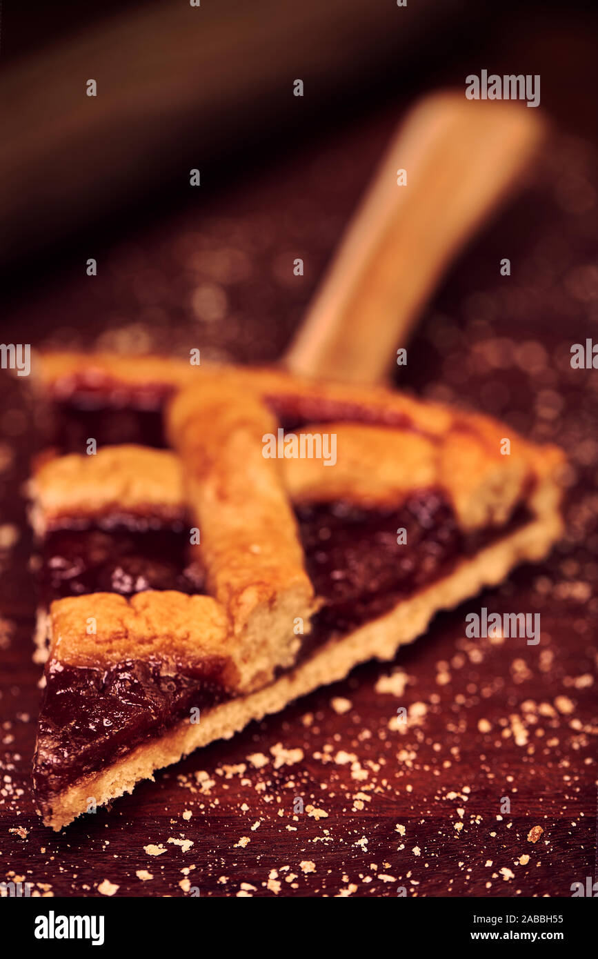 Fetta di Pasta Frola tart riempito di mela cotogna e gelatina di apple. Close-up. In legno rustico sfondo. Pastafrola argentino ricetta. Foto Stock