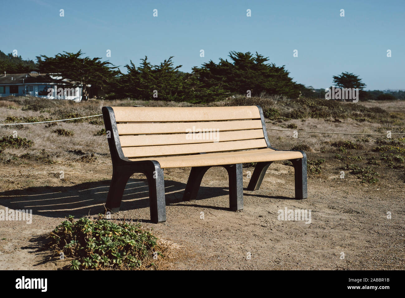 Vista di una panchina nel parco in riva al mare in una giornata di sole Foto Stock