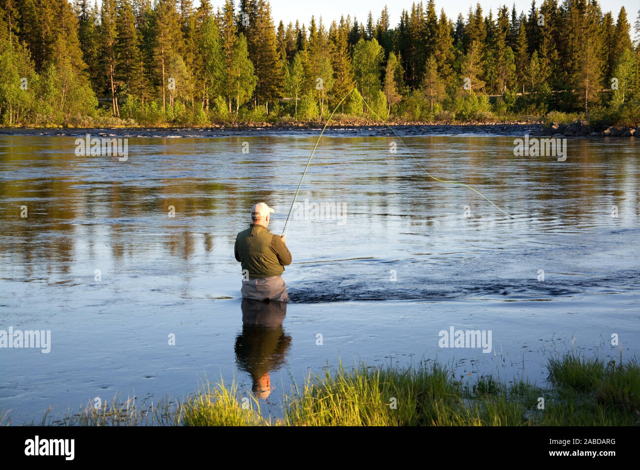 Il pescatore beim Fliegenfischen in einem Fluss am Abend. Foto Stock