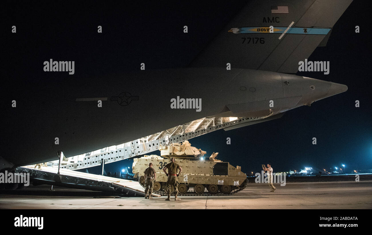 Stati Uniti Avieri assegnato al 386Expeditionary disponibilità logistica Squadron aiutare a guidare una U.S. Soldato dell'esercito del caricamento di un M2 Bradley combattendo il veicolo su un U.S. Air Force C-17 Globemaster III ad Ali Al Salem Air Base, Kuwait, Ottobre 30, 2019. Avieri e soldati gli sforzi coordinati per il trasporto del BFV all'interno degli STATI UNITI Comando centrale teatro di operazioni di assistenza nelle iniziative in corso all'interno della regione. (U.S. Air Force foto di Capt. Thomas Barger) Foto Stock