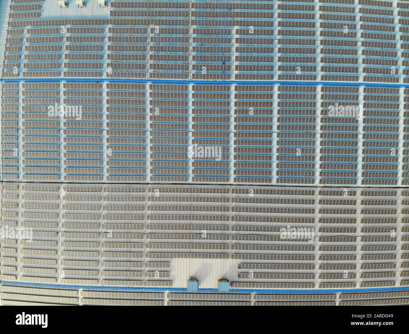 Una veduta aerea di celle fotovoltaiche (PV) celle sono installati sul tetto di una filanda, che mira a proteggere l'ambiente e ridurre i costi di energia elettrica, Foto Stock