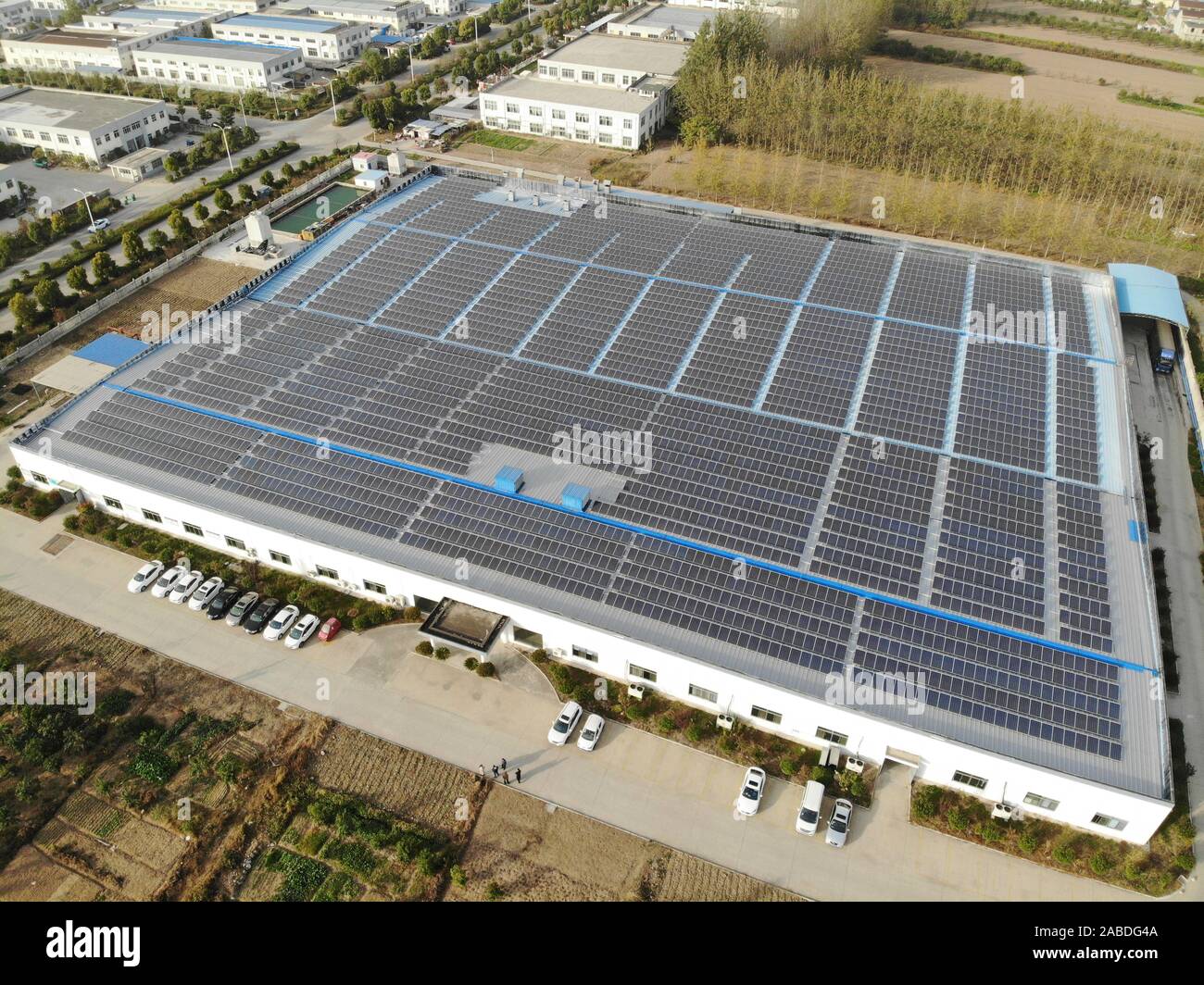 Una veduta aerea di celle fotovoltaiche (PV) celle sono installati sul tetto di una filanda, che mira a proteggere l'ambiente e ridurre i costi di energia elettrica, Foto Stock