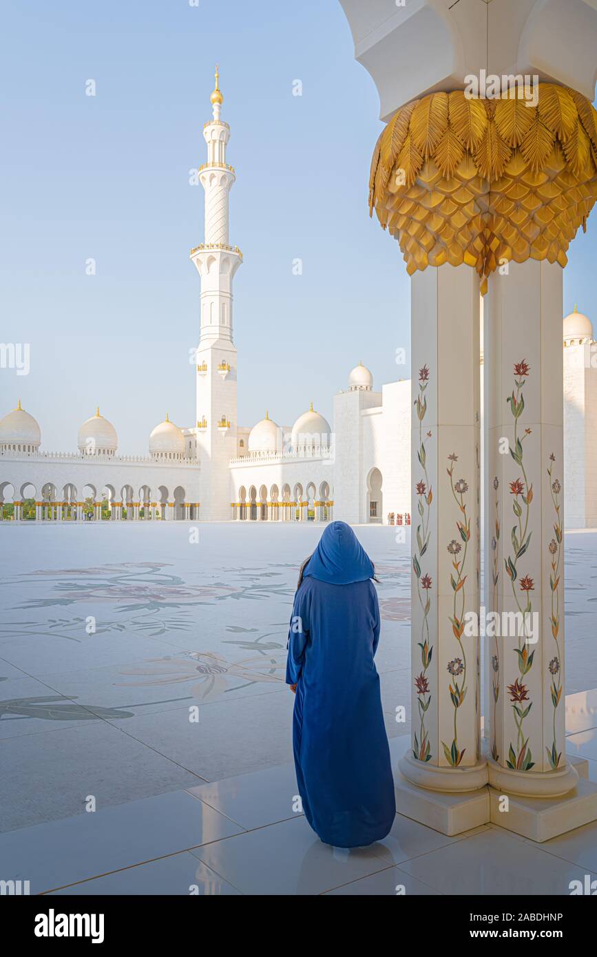 Donna in piedi Abu Dhabi Moschea durante il tramonto. Foto Stock